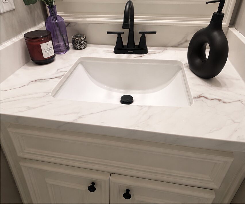 The same vanity with a white quartz top, matching backsplash and black fixtures