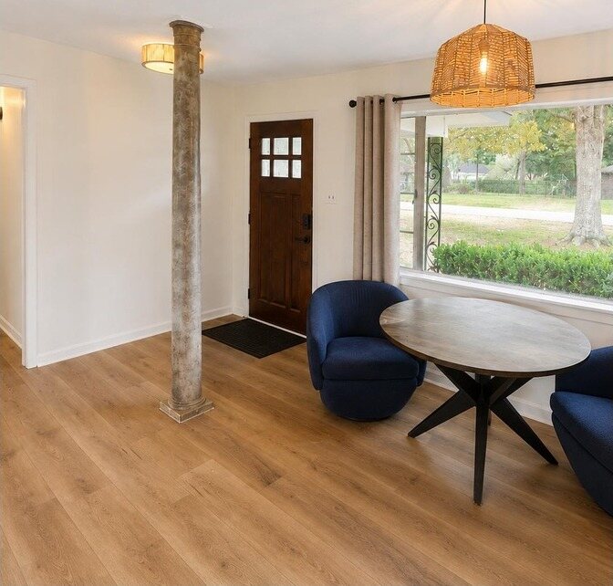 The same dining area in white with new wide plank flooring and new lighting