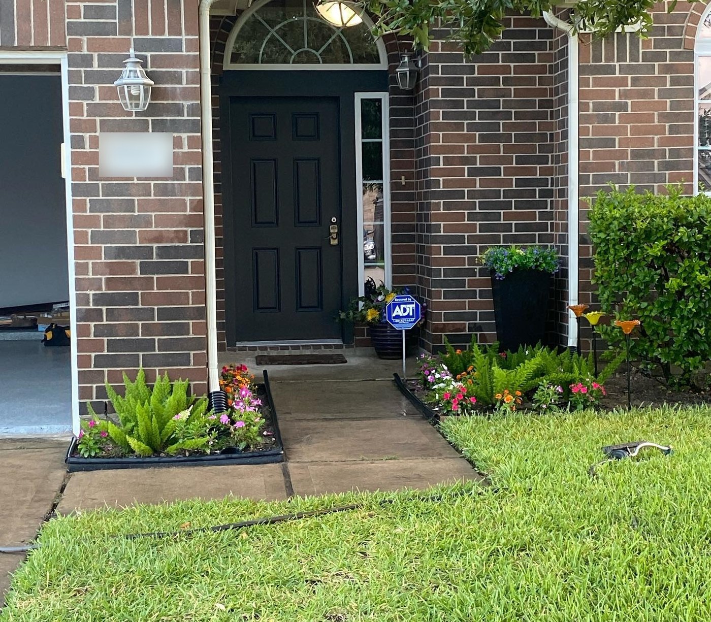 The same front door from outside in deep charcoal against the brick