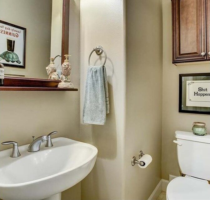 Guest bath with beige walls and a pedestal sink