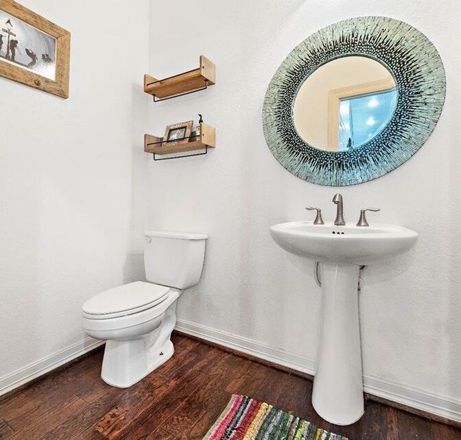 The same bath in white with a round mirror and new lighting
