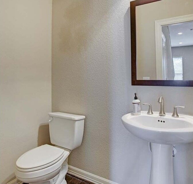 Guest bath with beige walls and a heavy dark mirror