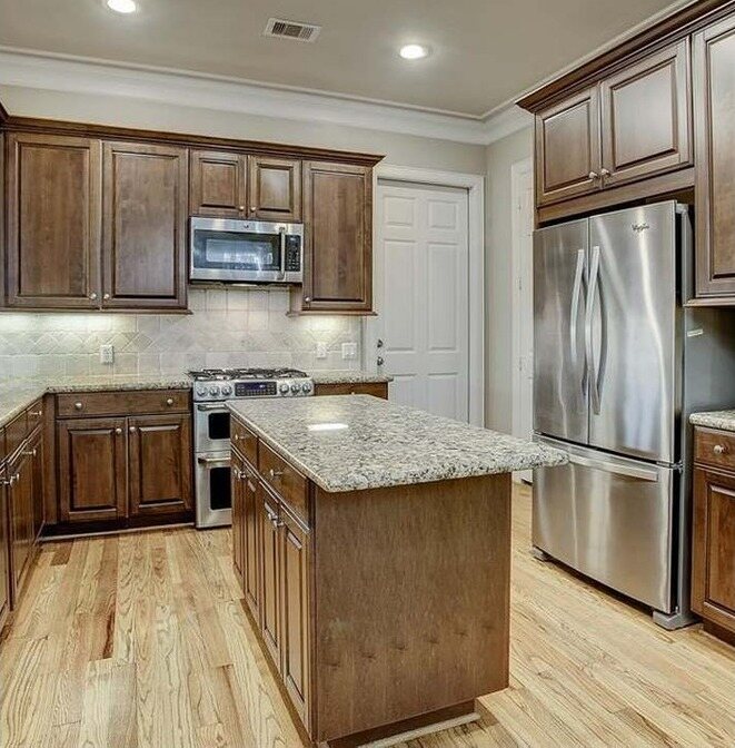 Kitchen with dark stained cabinets and granite counters