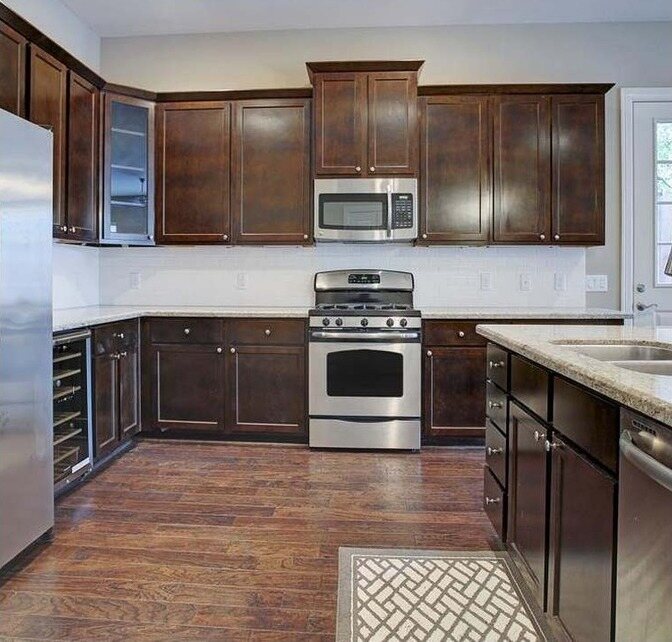 Kitchen with dark stained cabinets and beige walls