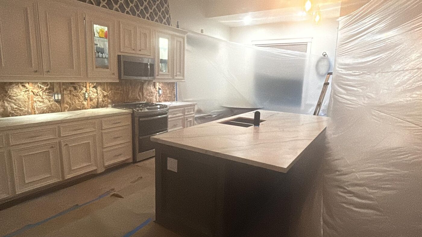 The kitchen sealed in plastic sheeting while the new tops go in